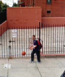Boy dribbling outside schoolyard